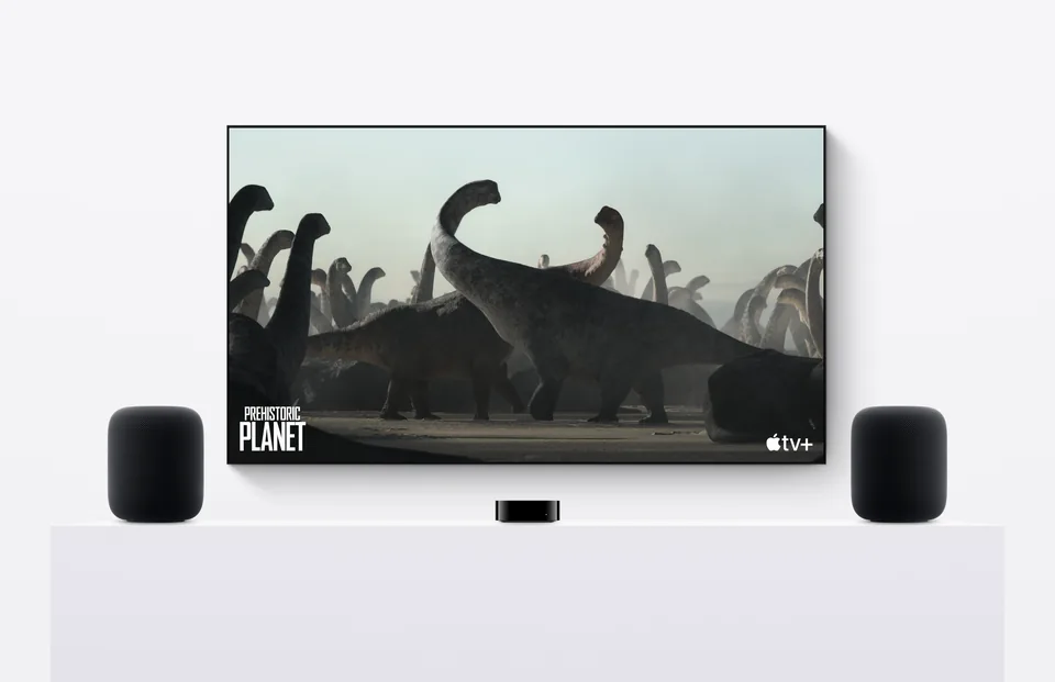 Two midnight second-generation Apple HomePod speakers beside a television and Apple TV