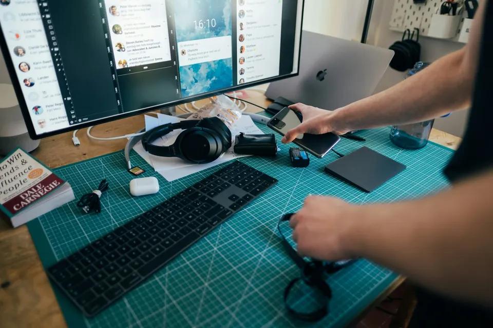 Person using a desktop computer with headphones on the desk